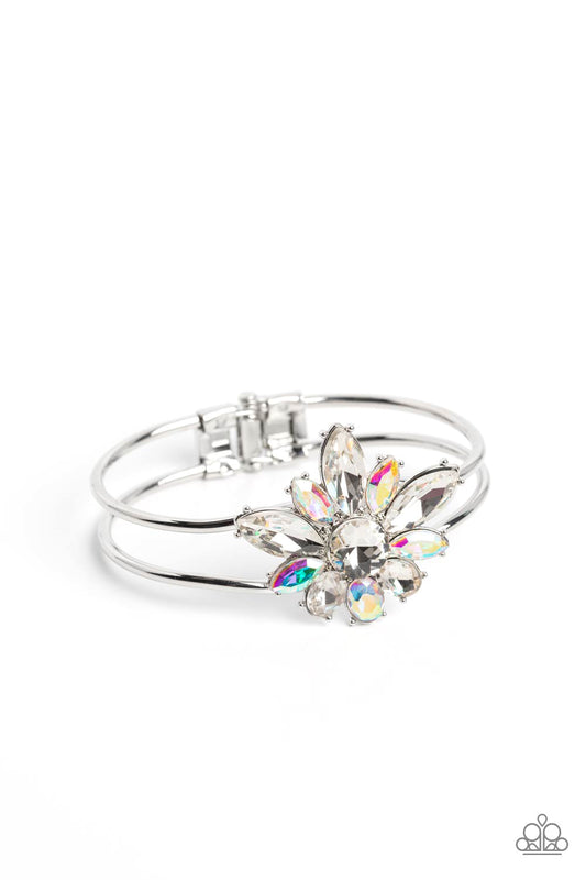Paparazzi Accessories Chic Corsage - White Varying sizes of oval and marquise-cut gems in shades of crystal white and shimmery iridescent bloom around a round-brilliant cut center in a similar crystal white hue. The dazzling collection of sparkly petals c