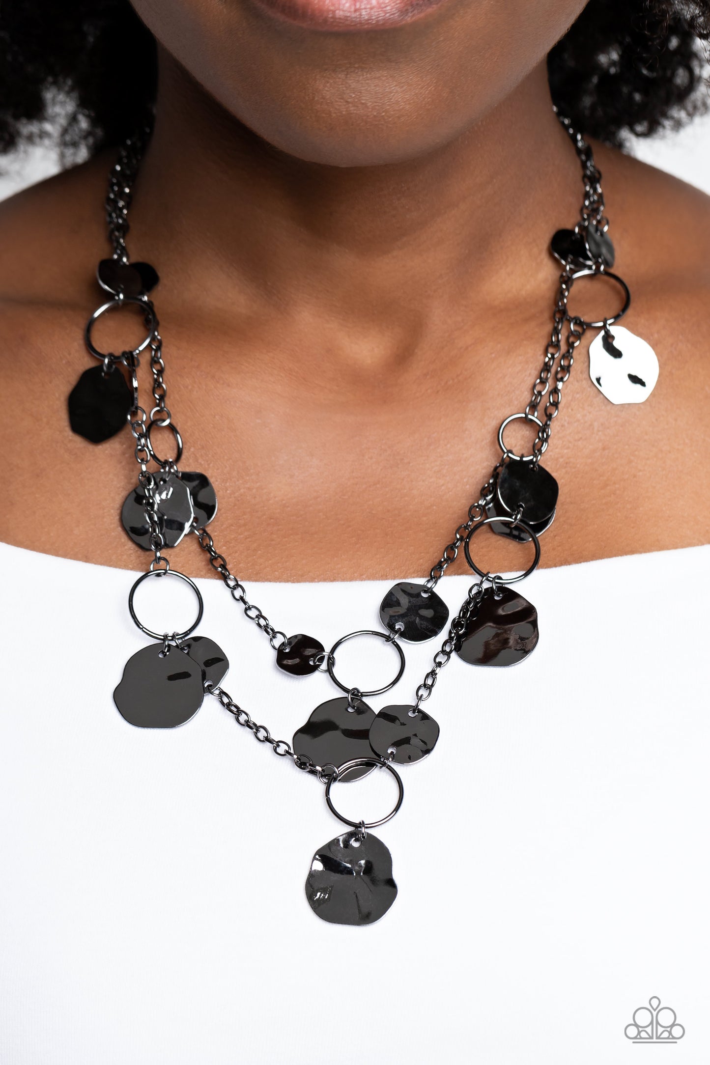 Paparazzi Accessories Hammered Horizons - Black Infused along a double-stranded gunmetal chain, smooth gunmetal hoops and abstract, hammered gunmetal discs fall down the neckline for an edgy, boisterous display. Features an adjustable clasp closure. Sold