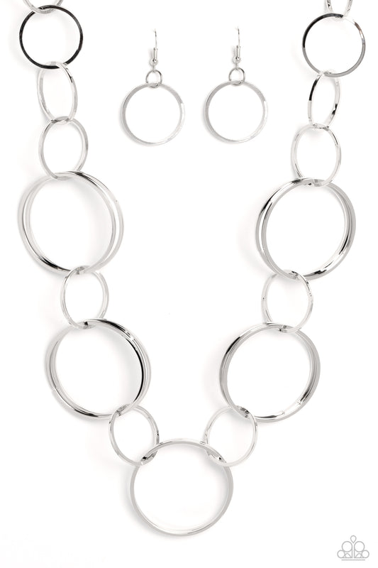 Paparazzi Accessories Shimmering Symphony - Silver A shimmering collection of thin silver hoops in varying sizes interlock and coalesce down the neckline for a refined monochromatic statement piece. Features an adjustable clasp closure. Sold as one indivi