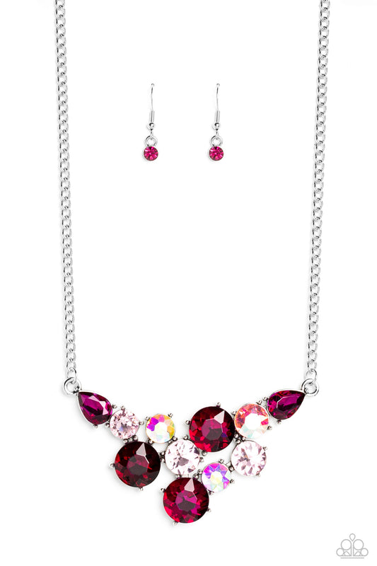 Paparazzi Accessories Round Royalty - Pink An explosion of round gems in varying sizes bordered by teardrop gems cluster together to create a glittery pink fringe down the neckline. Featured in fuchsia, light pink, and iridescent hues, each gem reflects l