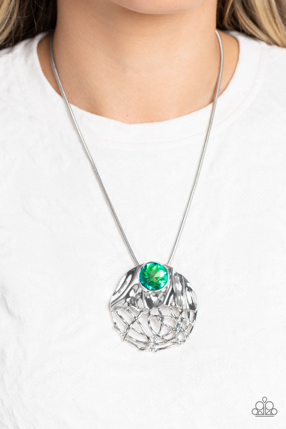 Paparazzi Accessories Lush Lattice - Green Mimicking a lattice-like pattern, abstract silver lines flow from the bottom of an oversized, hammered, silver half-circle pendant that attaches to a shimmery silver snake chain. Within the folds of the silver ha