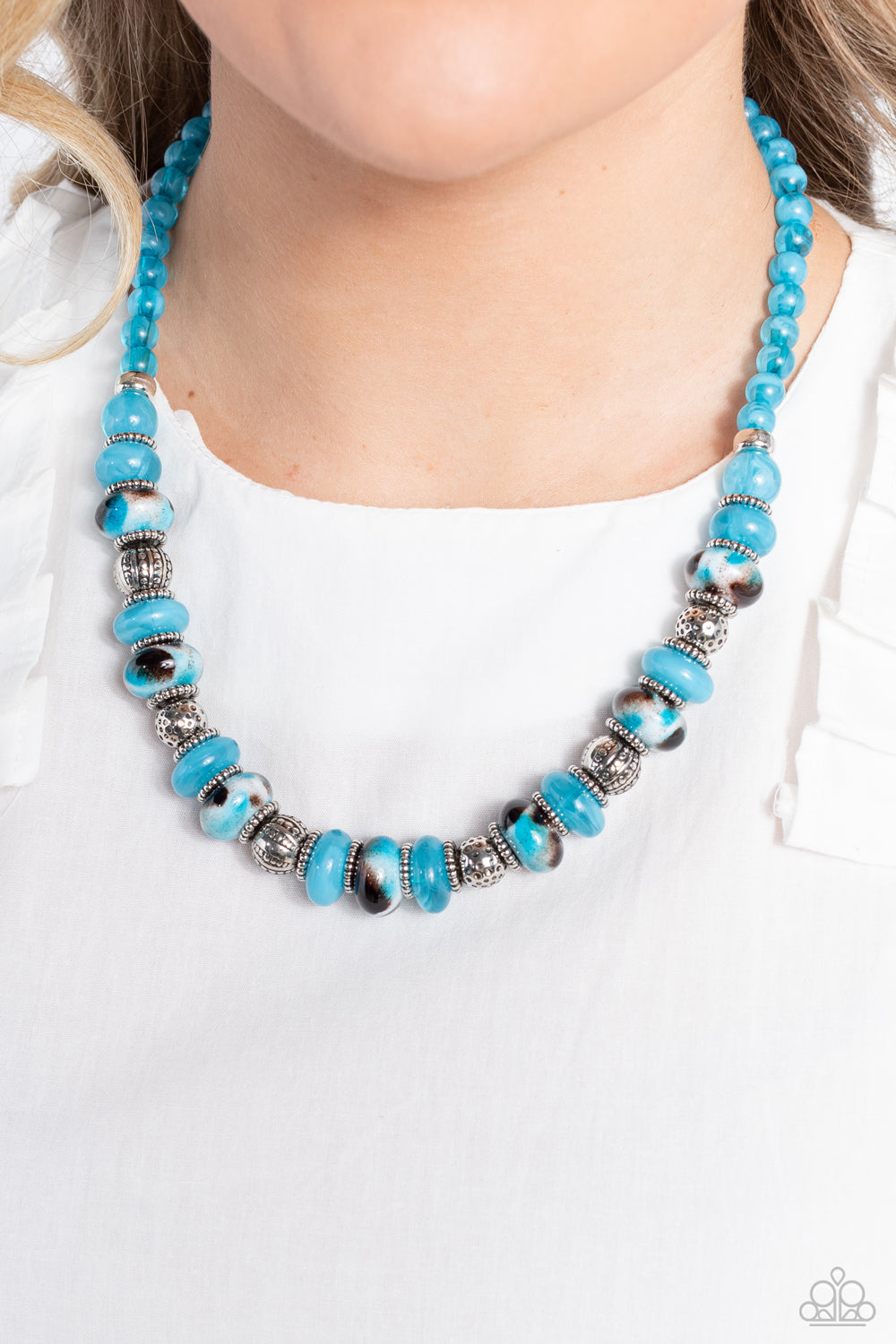 Paparazzi Accessories Warped Whimsicality - Blue An earthy collection of dotted silver beads, rounded milky turquoise beads, studded silver rings, turquoise-spotted ceramic-like beads and textured silver beads are threaded along an invisible wire below th