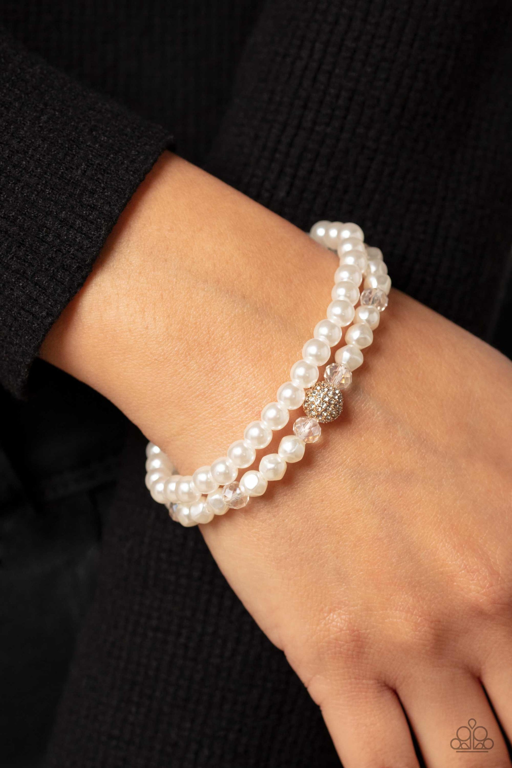 Paparazzi Accessories Countess Cutie - Gold A strand of classic white pearls and a strand of baroque white pearls coalesce around the wrist on stretchy bands for a refined finish. Infused along the baroque pearl strand, faceted crystal clear beads and a s