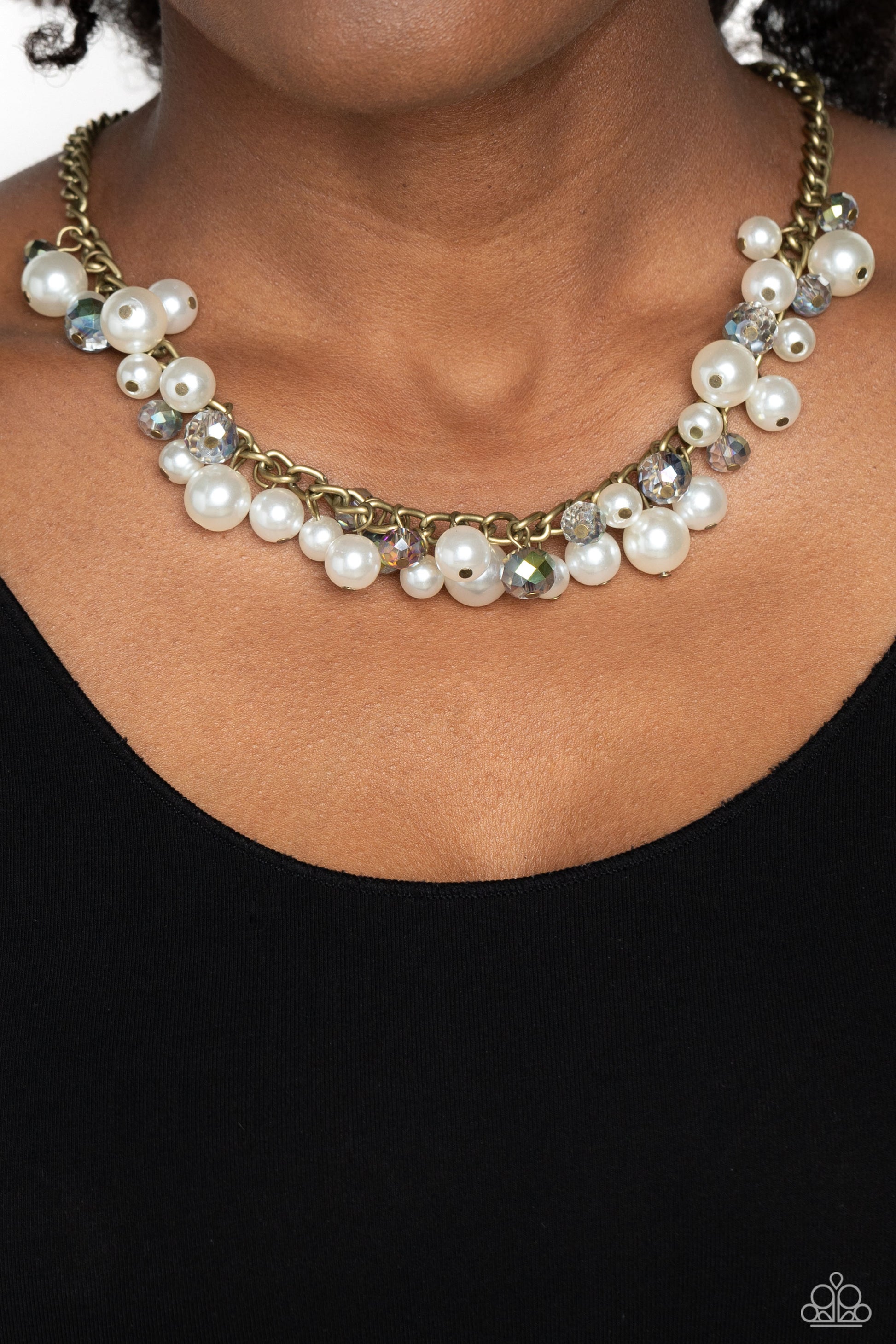 Paparazzi Accessories Glinting Goddess - Brass A faceted collection of glassy, UV reflective crystal-like beads and classic white pearls in varying sizes flickers and flashes below the collar on a thick brass curb chain for a refined shimmer. Features an