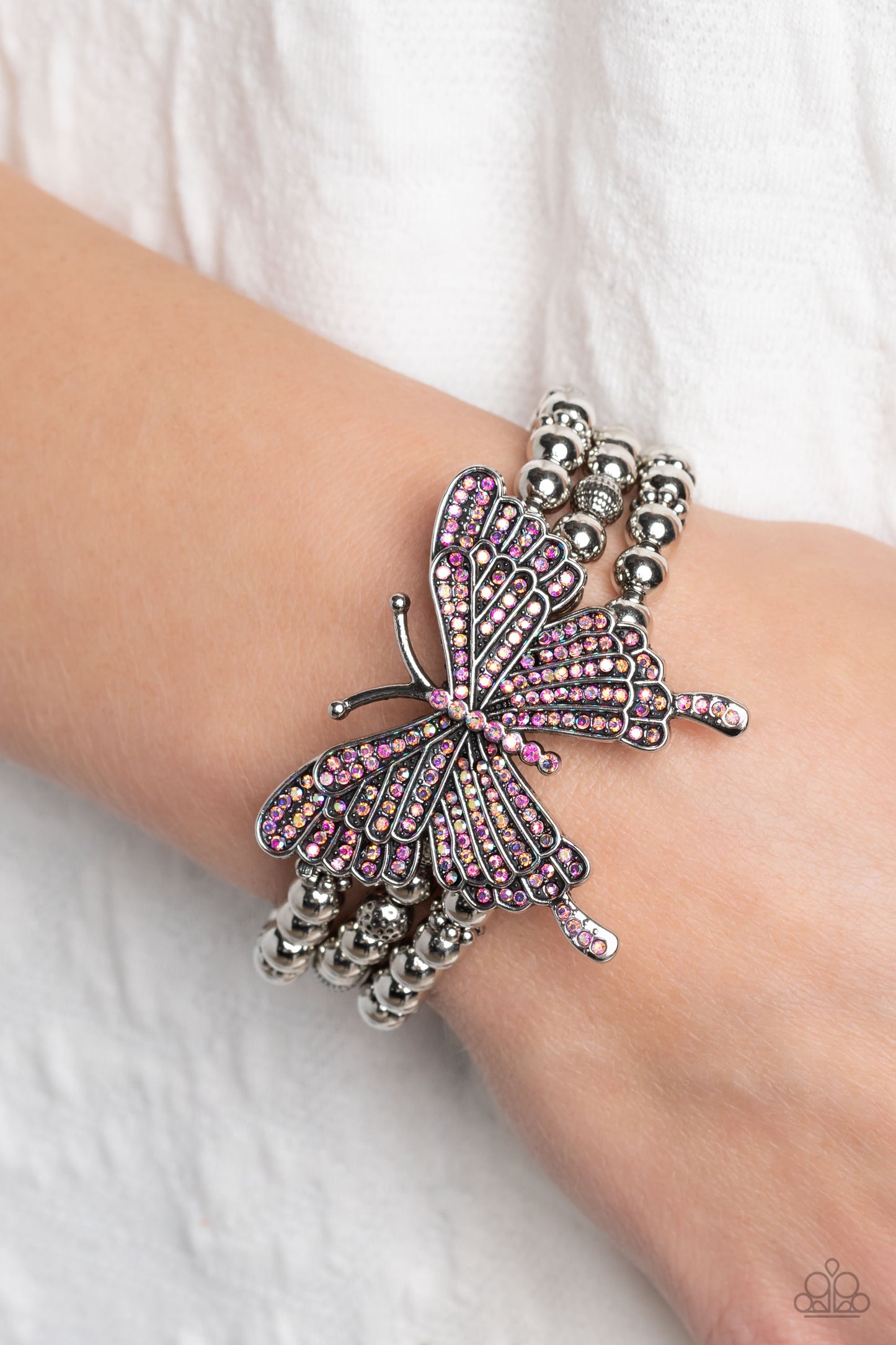Paparazzi Accessories First WINGS First - Pink Strung along elastic stretchy bands, a trio of silver and textured silver beads and accents wrap around the wrist. Featured atop the beaded collection, an oversized silver butterfly, with intricate details, i