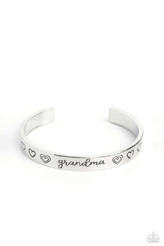 Paparazzi Accessories A Grandmothers Love - Silver Brushed in a polished sheen, a skinny silver bar curls around the wrist, creating a rustic cuff. Featuring a heart motif, the skinny cuff is engraved with the word “grandma” with various styles of hearts