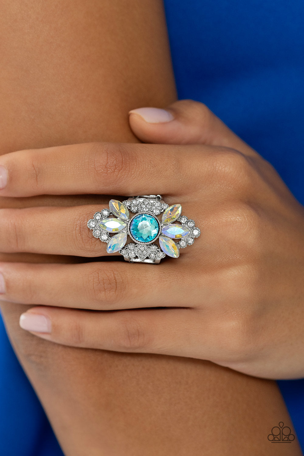 Paparazzi Accessories GLISTEN Here! - Blue Dotted with an effulgent display of sparkles, glistening dainty white rhinestones embedded in shiny silver filigree climb the finger, coalescing into a dramatic frame. Featured in the center of the glitzy display