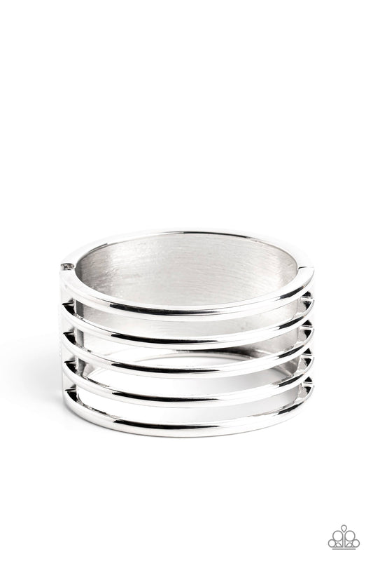 Paparazzi Accessories Wayward Warrior - Silver Stemming from a thick silver cuff, glistening bars of silver arc across the top of the wrist for a warrior-worthy finish. Features a hinged closure. Sold as one individual bracelet. Jewelry