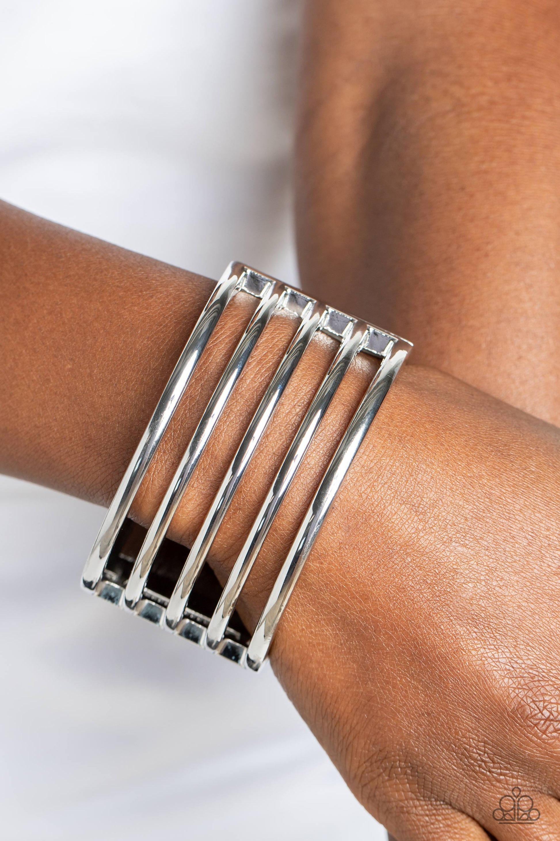 Paparazzi Accessories Wayward Warrior - Silver Stemming from a thick silver cuff, glistening bars of silver arc across the top of the wrist for a warrior-worthy finish. Features a hinged closure. Sold as one individual bracelet. Jewelry