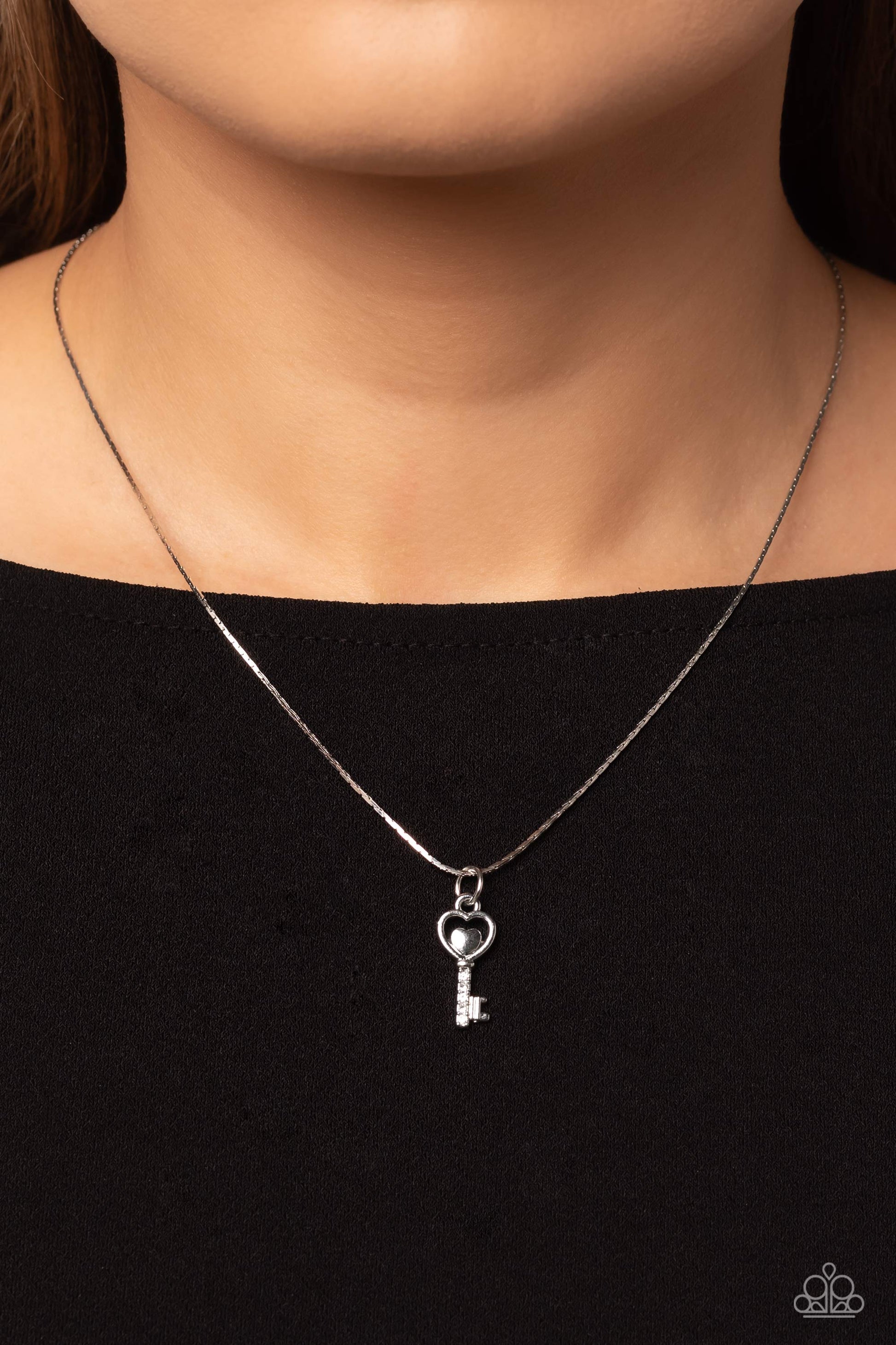 Paparazzi Accessories LOVE-Locked - White Dotted with glittery white rhinestones, a key pendant with a heart outline swings from the bottom of a dainty silver chain for a whimsical look. Features an adjustable clasp closure. Sold as one individual necklac