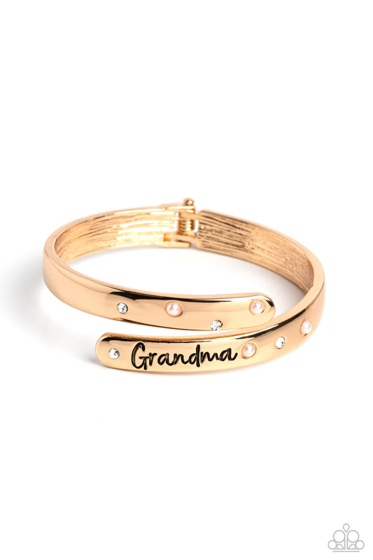 Paparazzi Accessories Gorgeous Grandma - Gold High-sheen gold curves into a hinged closure around the wrist. Featured on the upper curve, dainty pearls and white rhinestones alternate in a zig-zag pattern for a refined shimmer. The lower curve of gold fea