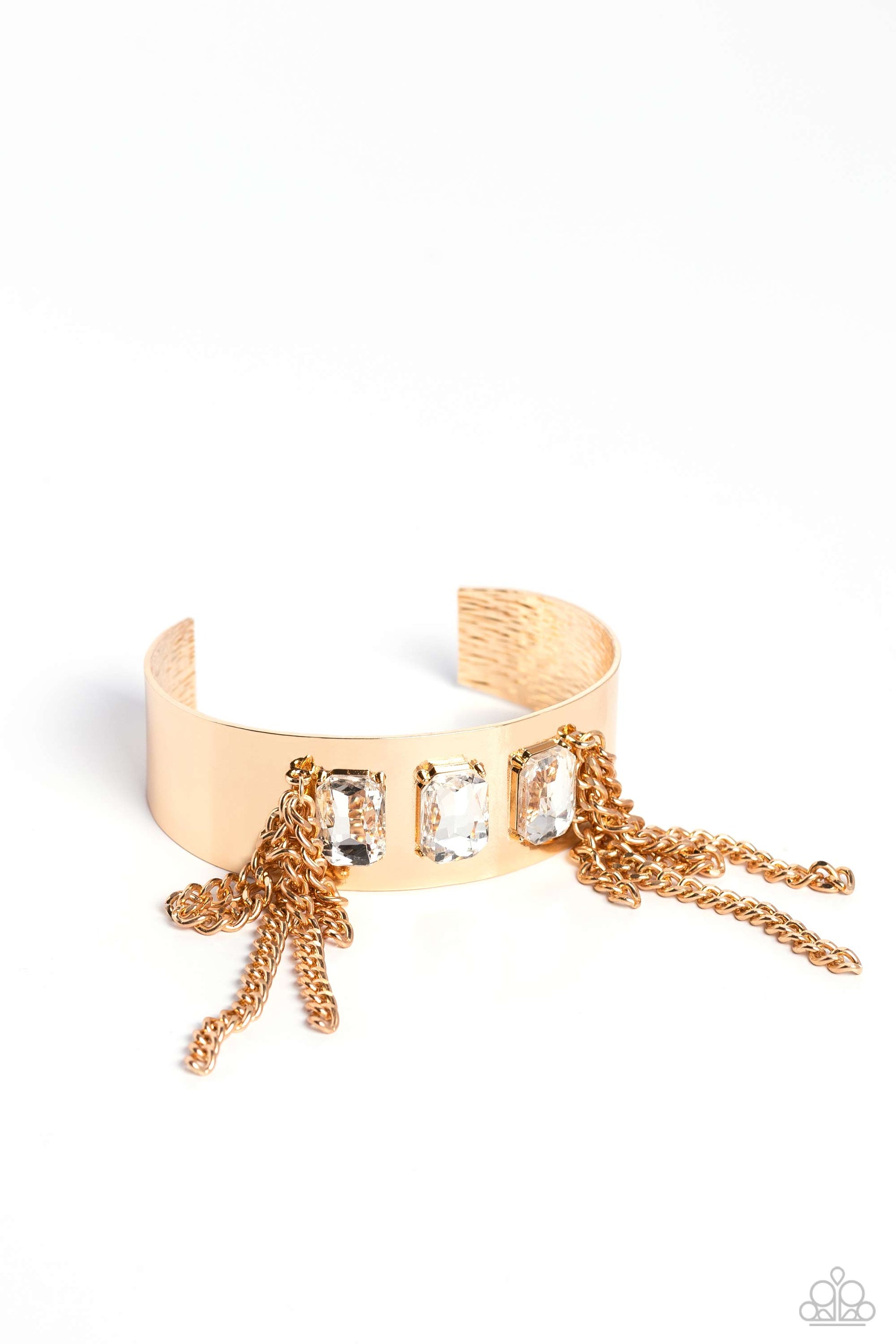 Paparazzi Accessories CHAIN Showers - Gold A thick, industrial gold cuff is topped by three brilliant white, emerald-cut gems. Strands of gold curb chain stream from each side of the trio of glitz, adding undeniable drama and eye-catching movement to the