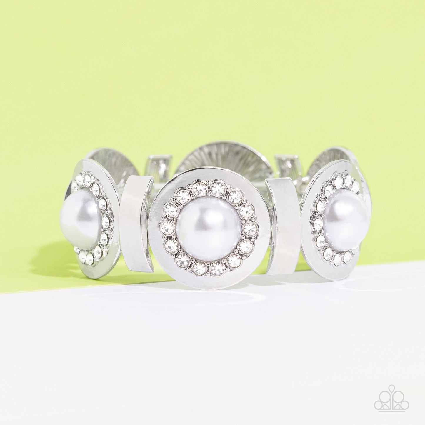 Paparazzi Accessories Summer Serenade - White Concaved silver frames, with an embossed row of white gems, encircle an oversized pearl center creating refined flowers. Sleek curls of silver alternate between the bejeweled flowers for additional shine and c