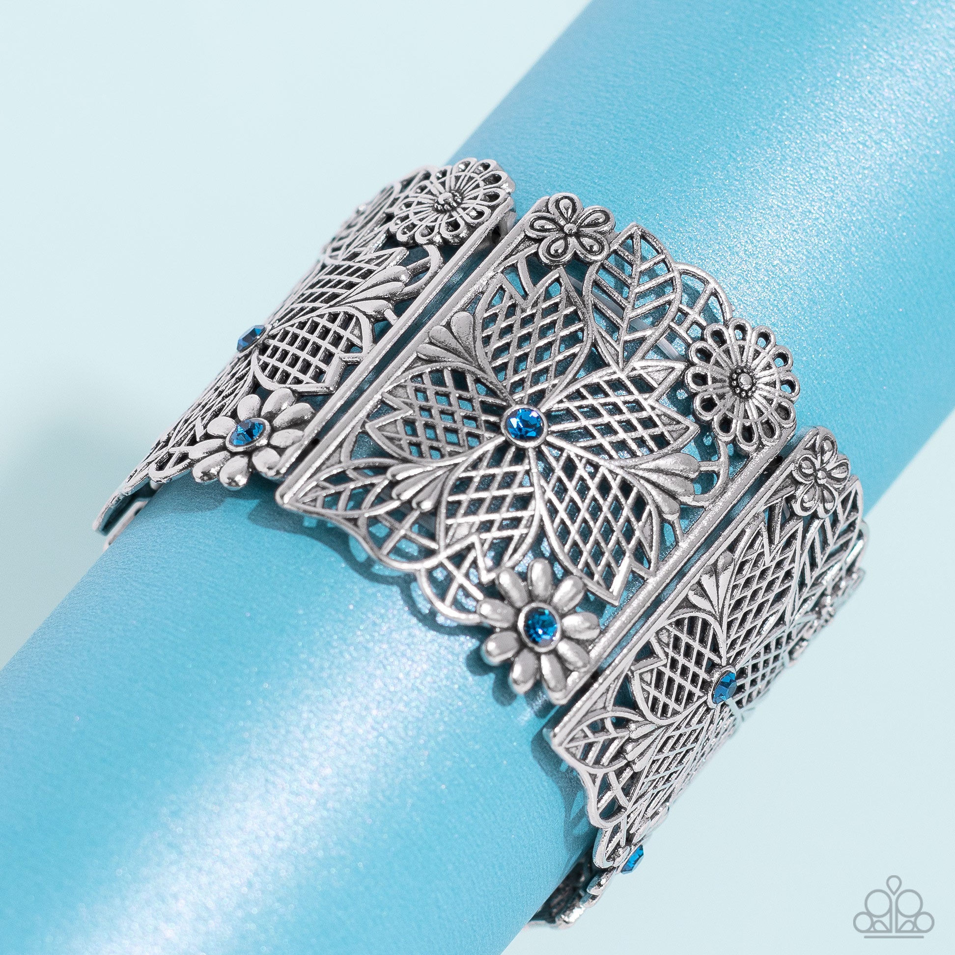 Paparazzi Accessories Garden City - Blue Featuring blue rhinestone centers, rectangular intricate, floral, filigree-filled silver frames are threaded along a stretchy band around the wrist for a whimsical garden-inspired look. Sold as one individual brace