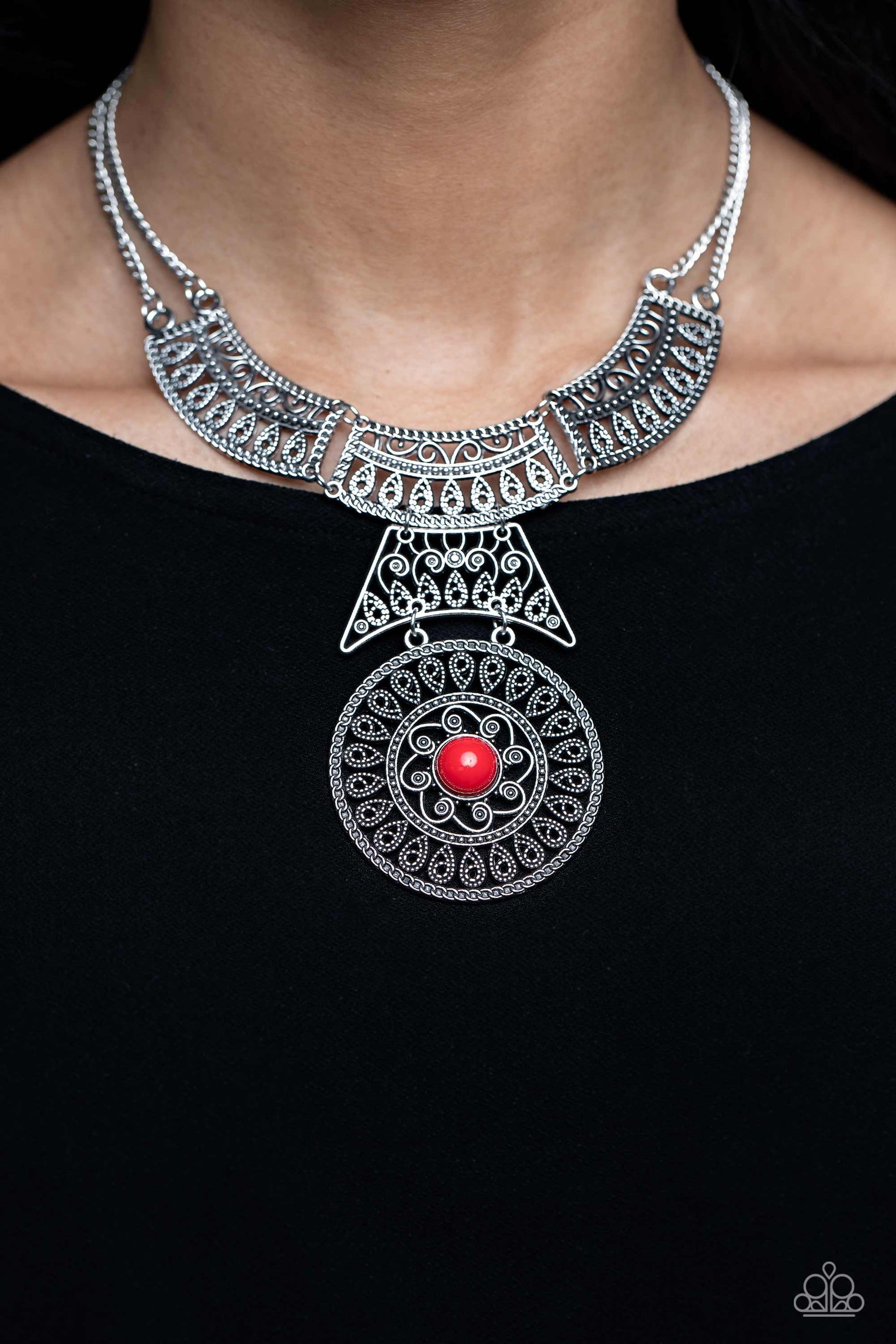 Paparazzi Accessories Fetching Filigree - Red Rows of oversized silver filigree frames stack into a crescent-shape that is anchored by additional silver filigree frames that layer down the neckline. Featured in the center of the lowermost circular frame,