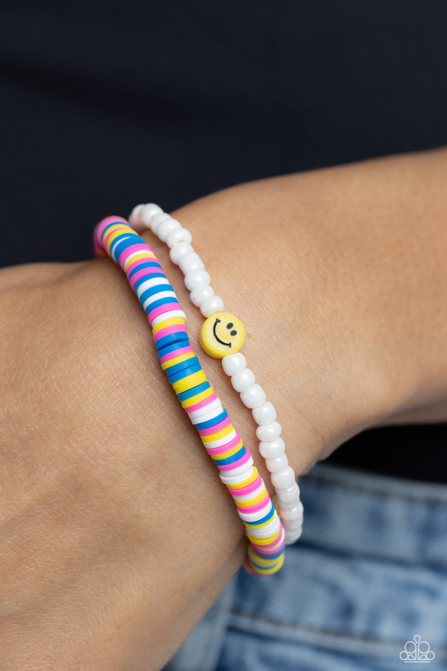 Paparazzi Accessories Tabloid Talent - Multi Hot pink, blue, white, and yellow clay discs combine with a strand of white seed beads to provide a vibrant pop of color along the wrist. Sporadically dotted in the high-sheen seed bead strand, yellow smiley fa