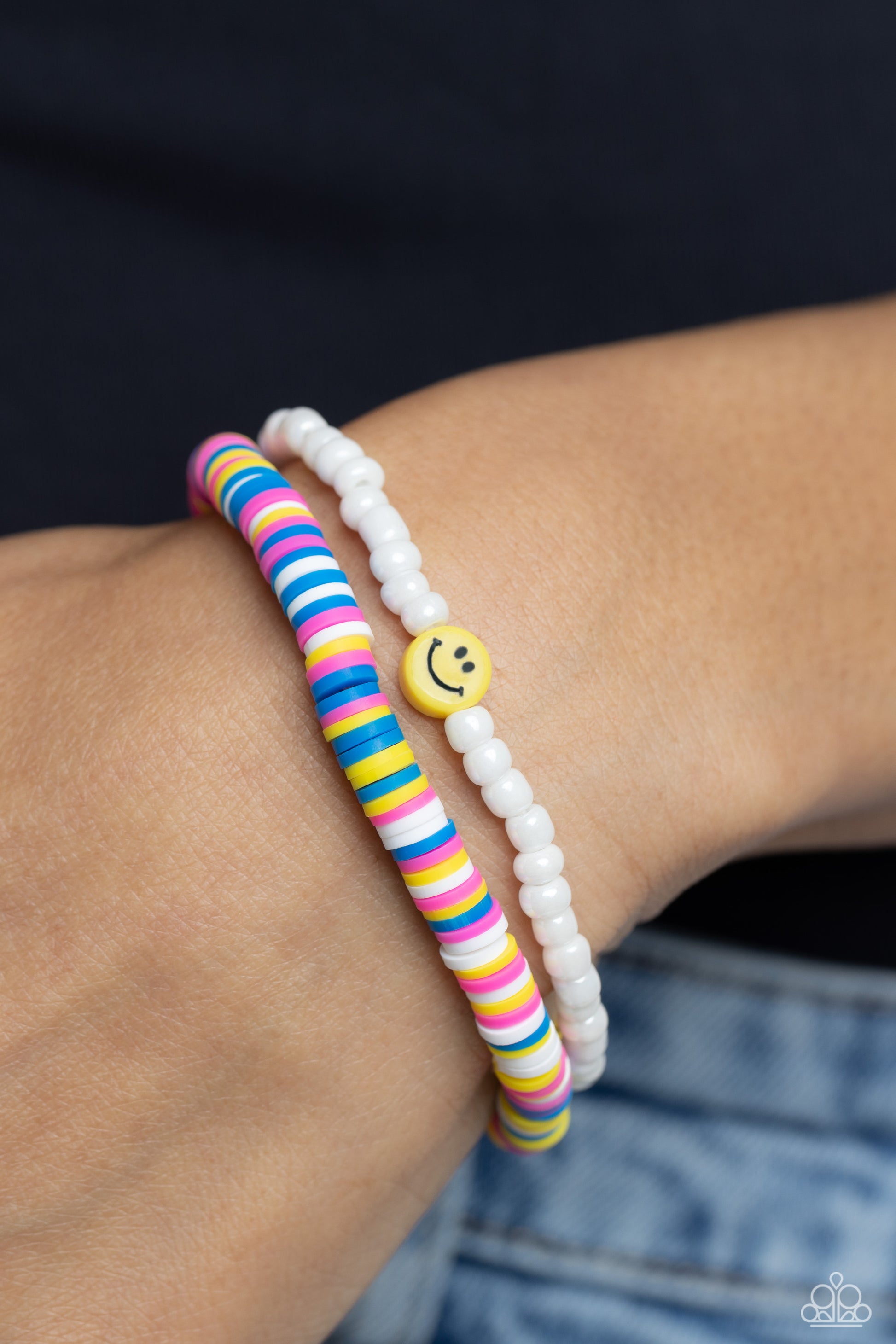 Paparazzi Accessories Tabloid Talent - Multi Hot pink, blue, white, and yellow clay discs combine with a strand of white seed beads to provide a vibrant pop of color along the wrist. Sporadically dotted in the high-sheen seed bead strand, yellow smiley fa