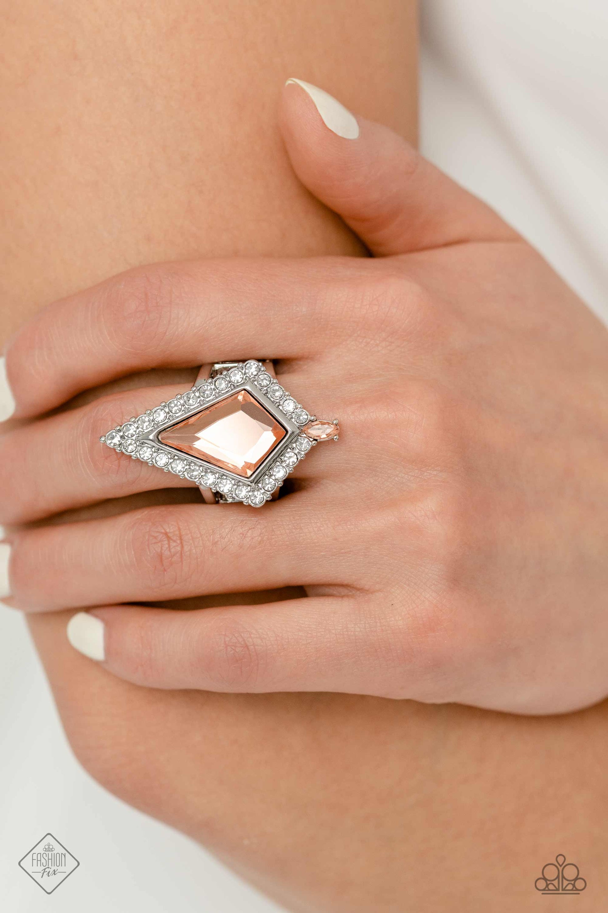 Paparazzi Accessories Stylish Studio - Orange Pressed in a border of white gems and dainty silver studs, a dramatic kite-shaped peach gem stands out atop the finger. A dainty marquise-cut peach gem is pressed into the dramatic fringe, adding an additional