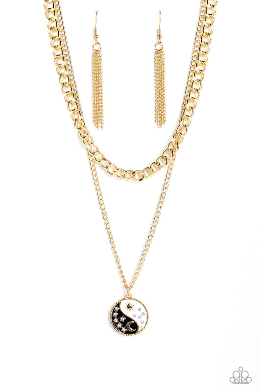 Paparazzi Accessories Night and Day - Black Featuring a yin-yang design, a gold moon with rhinestone-dusted stars rests on the black curve, while a gold sun with rhinestone beams of light rests on the white curve for a balanced, studded display down the n