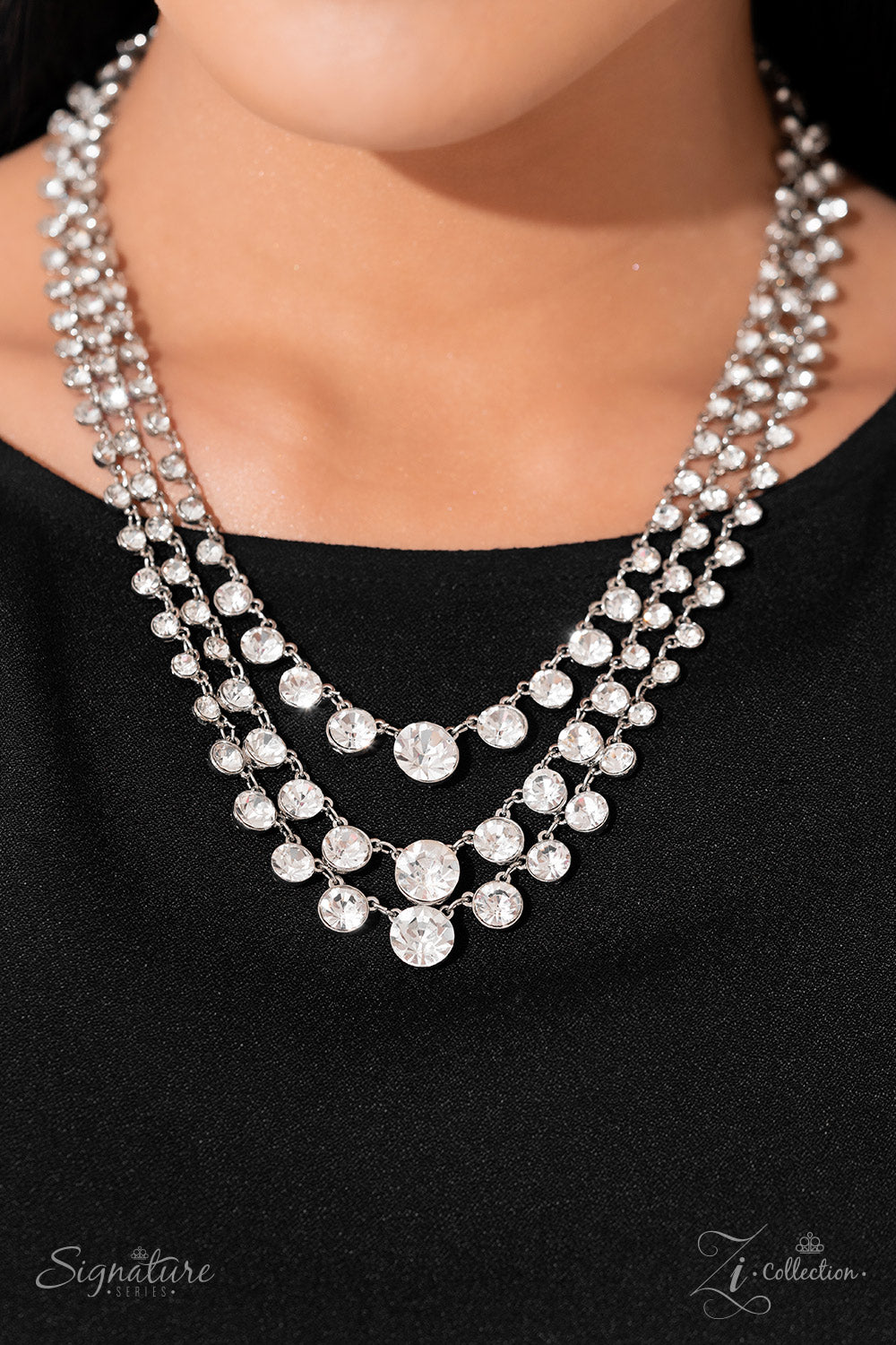 Paparazzi Accessories The Dana Rows of glittery, white rhinestones drape between two sleek silver bars, falling into three luxurious layers. The sparkling gems gradually increase in size as they fall towards the center of the design, adding dazzling dimen