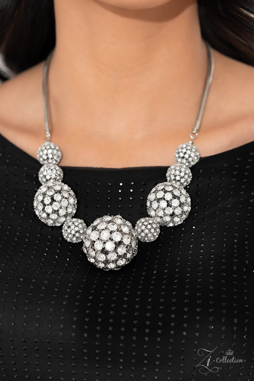 Paparazzi Accessories Undaunted - White Glittery, white rhinestones cluster together, creating dramatically oversized, airy, spheres that sparkle vivaciously. Smaller rhinestone-encrusted spheres dance between the exaggerated accents, resulting in a dynam