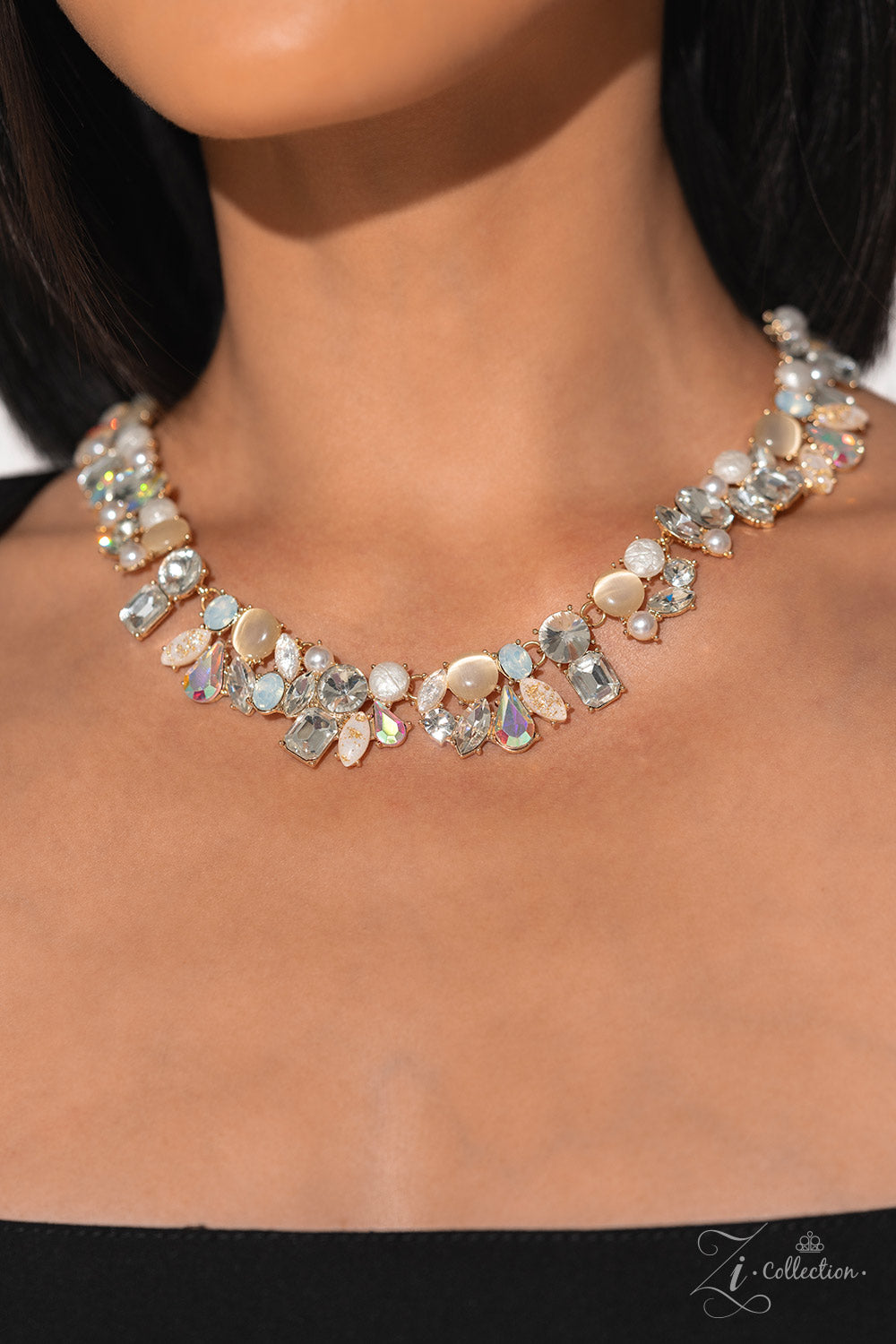 Paparazzi Accessories Enchanting - Gold A treasure trove of textures and sheen emerges along the neckline, as a collection of beads, gems, and pearls group into haphazard clusters. From iridescent teardrops to glowing cat’s eyes, emerald-cut rhinestones t