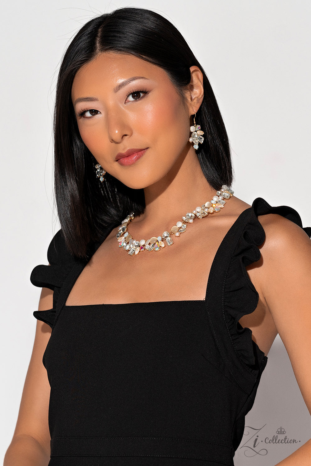 Paparazzi Accessories Enchanting - Gold A treasure trove of textures and sheen emerges along the neckline, as a collection of beads, gems, and pearls group into haphazard clusters. From iridescent teardrops to glowing cat’s eyes, emerald-cut rhinestones t