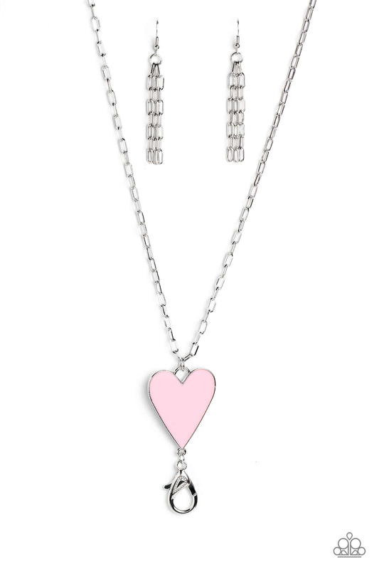 Paparazzi Accessories Subtle Soulmate - Pink *Lanyard Shiny silver oval links coalesce down the neck on an elongated chain, meeting a baby pink heart pendant wrapped in an understated silver frame for a colorfully romantic finish. A lobster clasp hangs fr