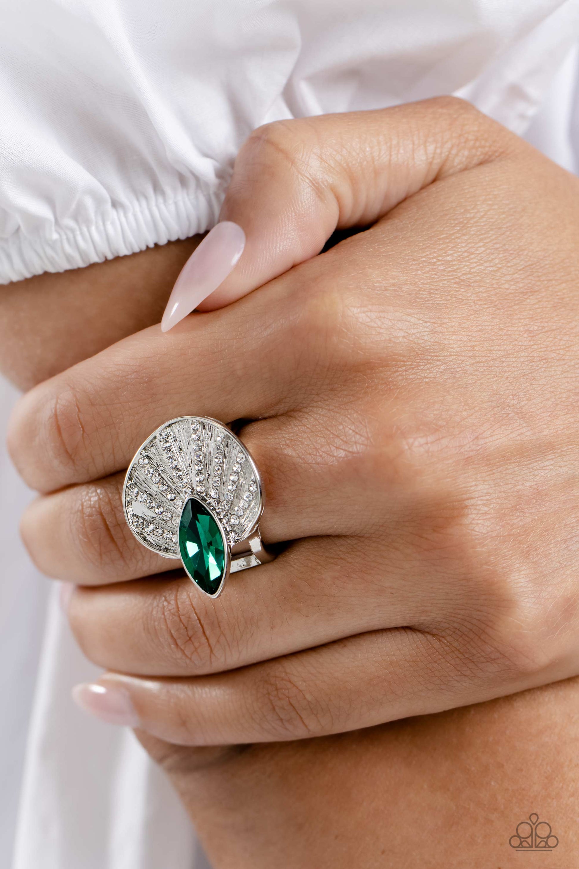 Paparazzi Accessories Fan Dance Dazzle - Green An asymmetrical silver disc, featuring linear layers of dainty white rhinestones against a textured backdrop, reflect light off its every angle from airy silver bands. A marquise-cut green gem interrupts the