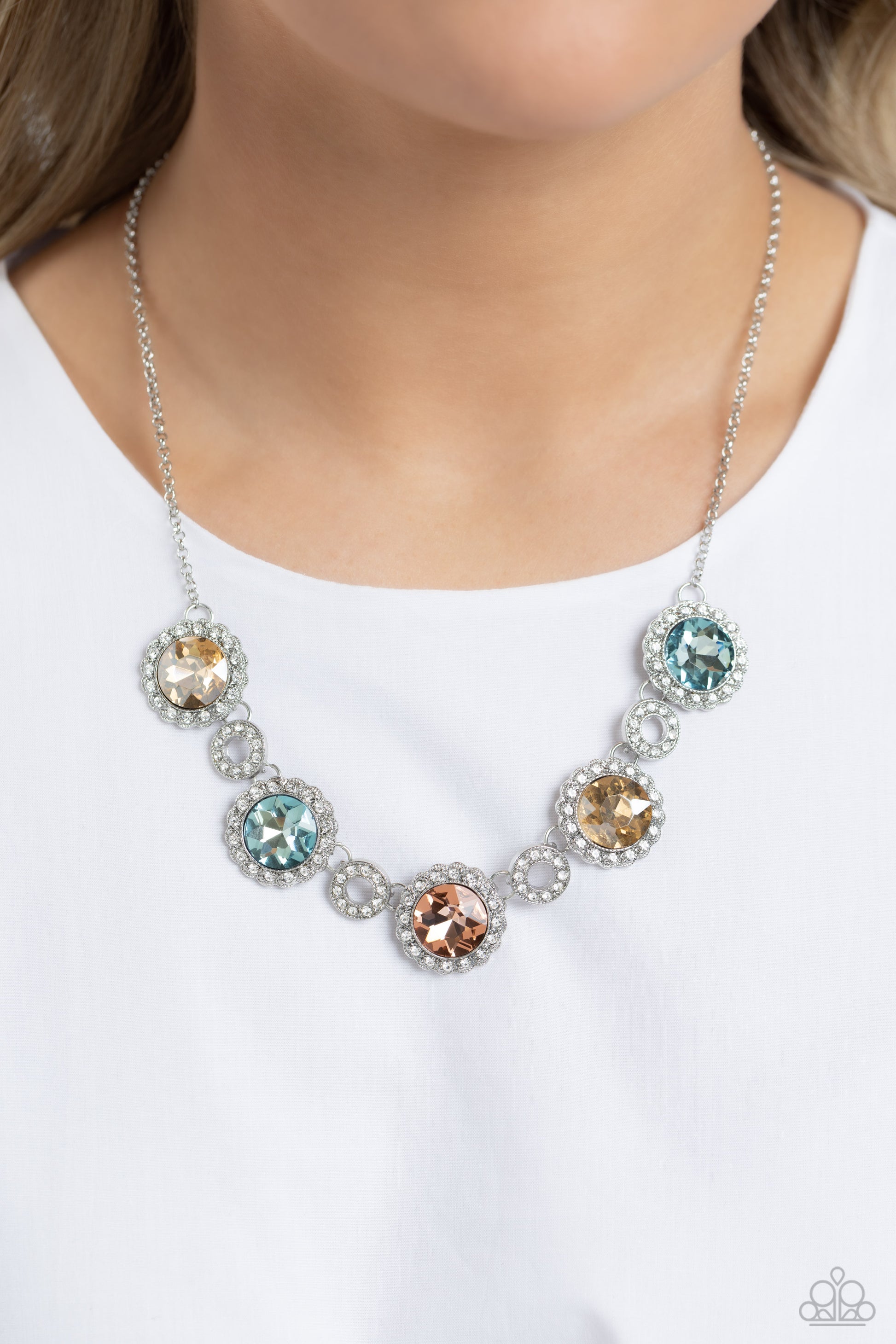 Paparazzi Accessories Gorgeous Gems - Multi Oversized, faceted blue, peach, and golden gems are encircled by a smoldering collection of dainty white glitz, creating a scalloped collection of stunning floral frames. Smaller, textured discs, embossed with d