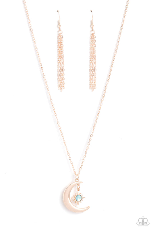 Paparazzi Accessories Stellar Sway - Rose Gold A glassy blue bead is pressed into the center of a three-dimensional rose gold star that dances from the top of a rose gold crescent moon pendant, creating a celestial pendant at the bottom of a dainty rose g
