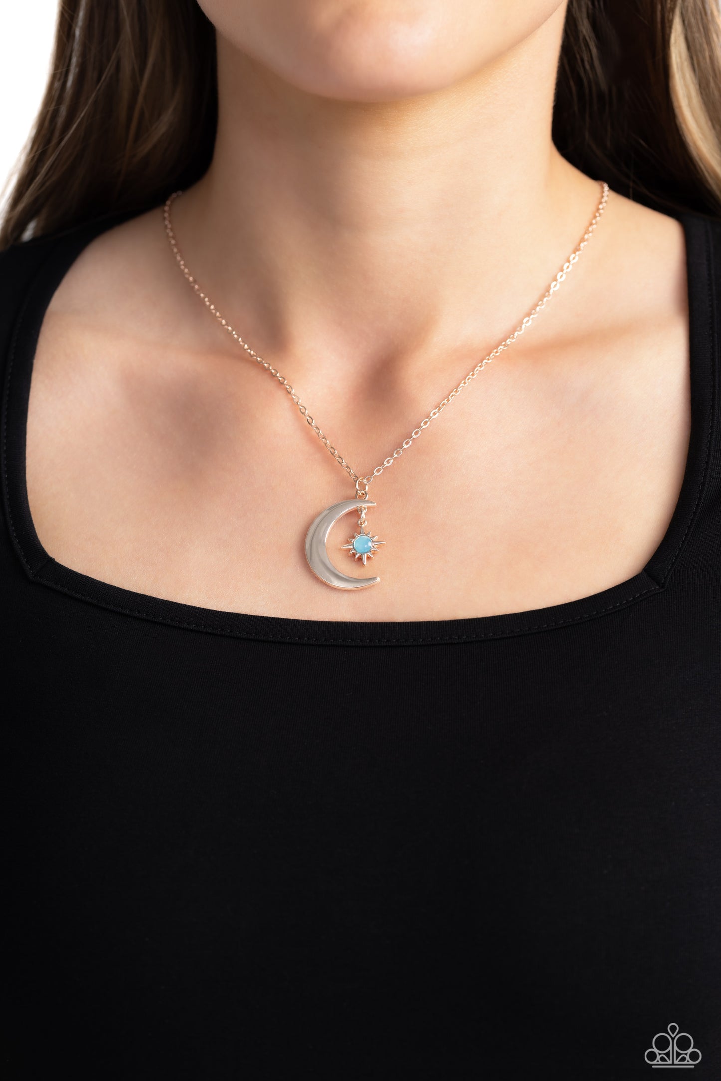 Paparazzi Accessories Stellar Sway - Rose Gold A glassy blue bead is pressed into the center of a three-dimensional rose gold star that dances from the top of a rose gold crescent moon pendant, creating a celestial pendant at the bottom of a dainty rose g