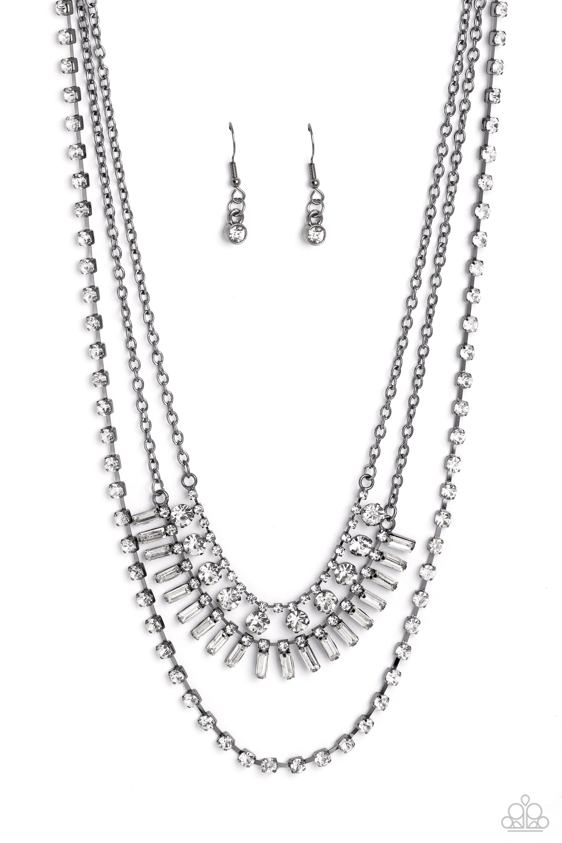 Paparazzi Accessories Dripping in Stardust - Black Three gunmetal chains fall into haphazard layers across the chest, creating a radiantly edgy display. On the uppermost chain, a row of solitaire rhinestones emerges from a section of small, white, square-