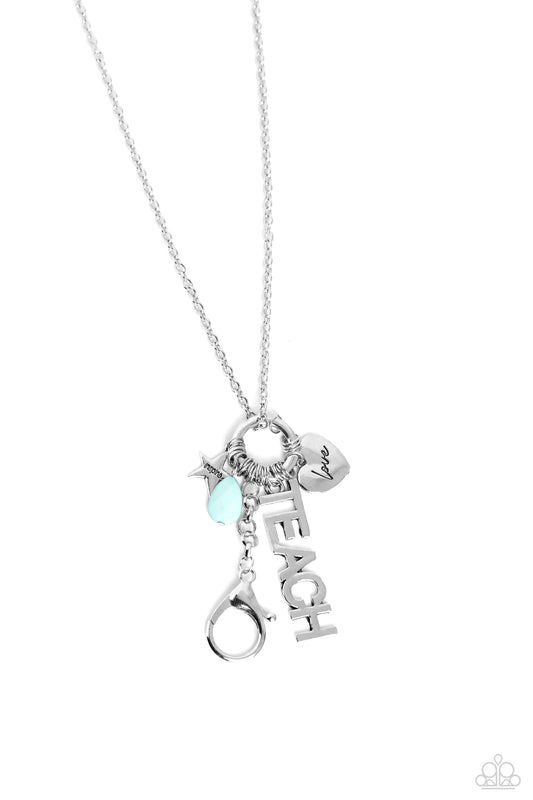 Paparazzi Accessories School Teacher - Blue Accented with a faceted turquoise teardrop, a collection of silver shapes, including a heart, stamped with the word "love" and a star stamped with the word "inspire," cascades at the bottom of a lengthened silve