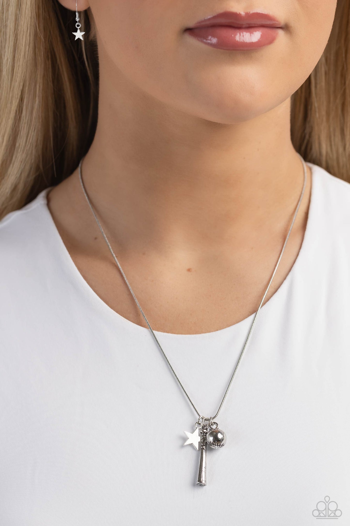 Paparazzi Accessories Hey Batter Batter! - Silver An assortment of charms, including a star, baseball, and baseball bat, glide along a dainty silver snake chain, creating a simply sporty display below the collar. Features an adjustable clasp closure. Sold