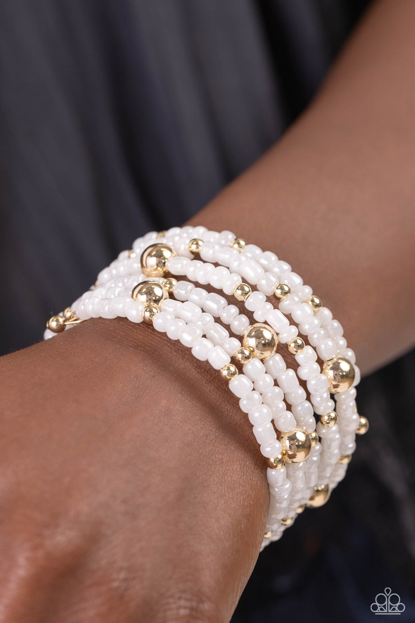 Paparazzi Accessories Refined Retrograde - Gold Pearly white seed beads, and various-sized gold accents are threaded along a coiled wire, creating a refined infinity wrap-style bracelet around the wrist. Sold as one individual bracelet Jewelry