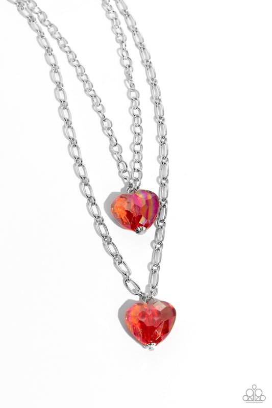 Paparazzi Accessories Layered Love - Red Featuring a subtle iridescent shimmer, two glassy red gem hearts are delicately suspended above one another on a paperclip and silver oval link chain for a whimsical double-stacked display. Features an adjustable c
