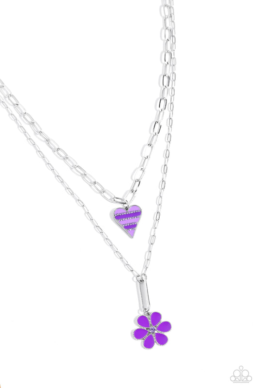 Paparazzi Accessories Childhood Charms - Purple Featuring dainty purple rhinestones, an elongated silver heart charm with stripes of lavender and purple paint, trickles along a shimmery silver paperclip link chain. A studded silver flower, with purple pet