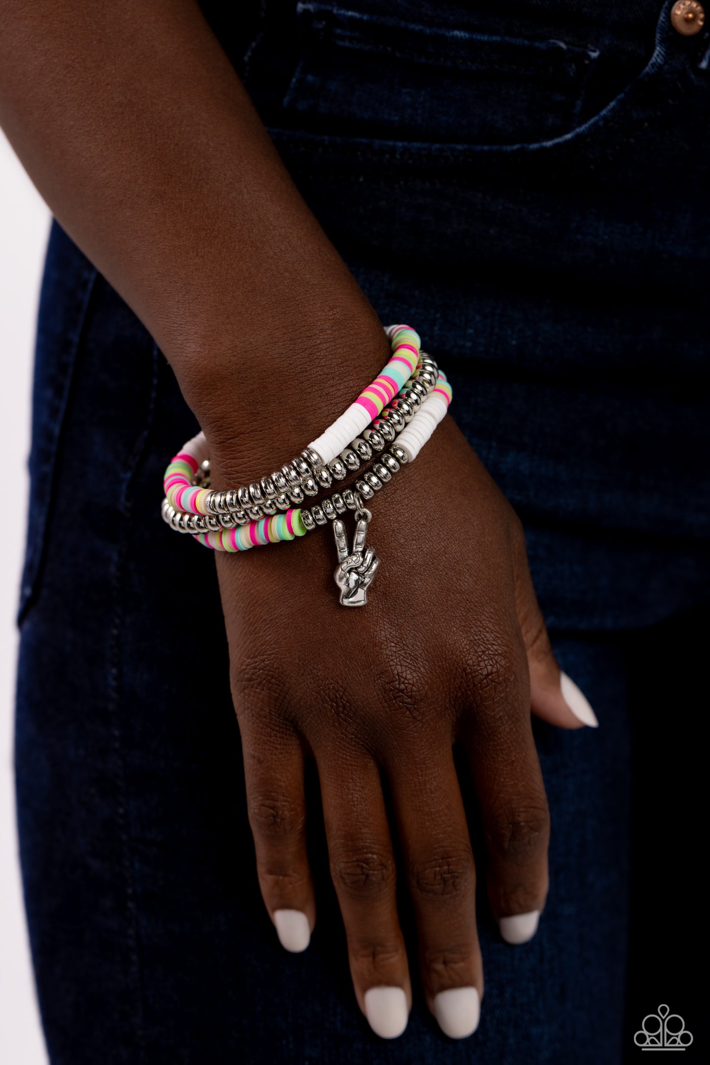 Paparazzi Accessories Peaceful Potential - White Infused along stretchy bands white, pink, green, blue, and tan rubber discs combine with sporadically placed silver discs and a silver disc strand for a vibrant pop of color along the wrist. A silver peace