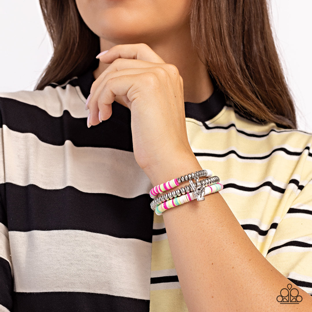 Paparazzi Accessories Peaceful Potential - White Infused along stretchy bands white, pink, green, blue, and tan rubber discs combine with sporadically placed silver discs and a silver disc strand for a vibrant pop of color along the wrist. A silver peace