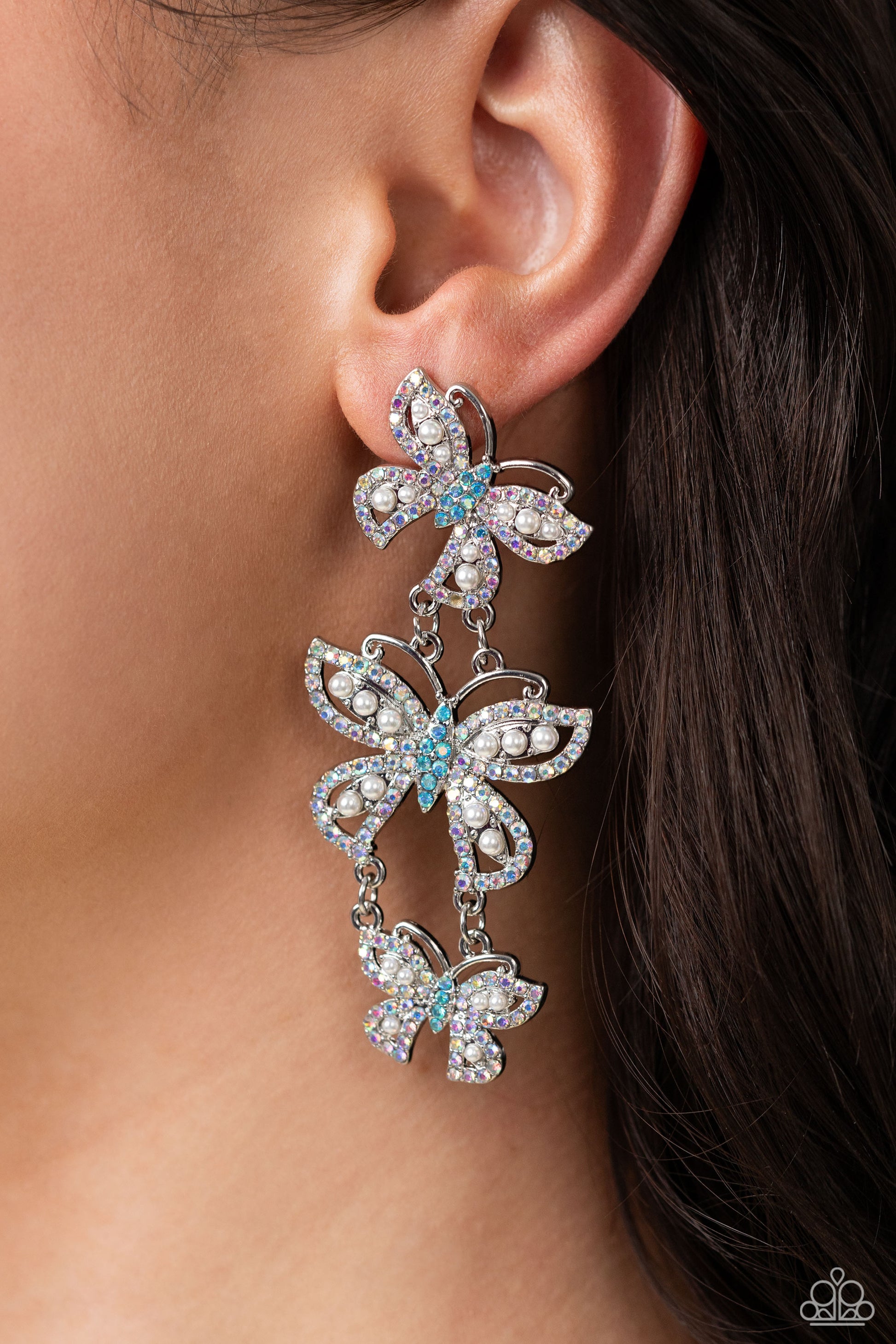 Paparazzi Accessories Fluttering Finale - Multi An airy trio of silver butterflies of various sizes link into a whimsical lure. Each butterfly's wings have been dipped in iridescent rhinestones and white pearls, while the bodies are dipped in blue iridesc