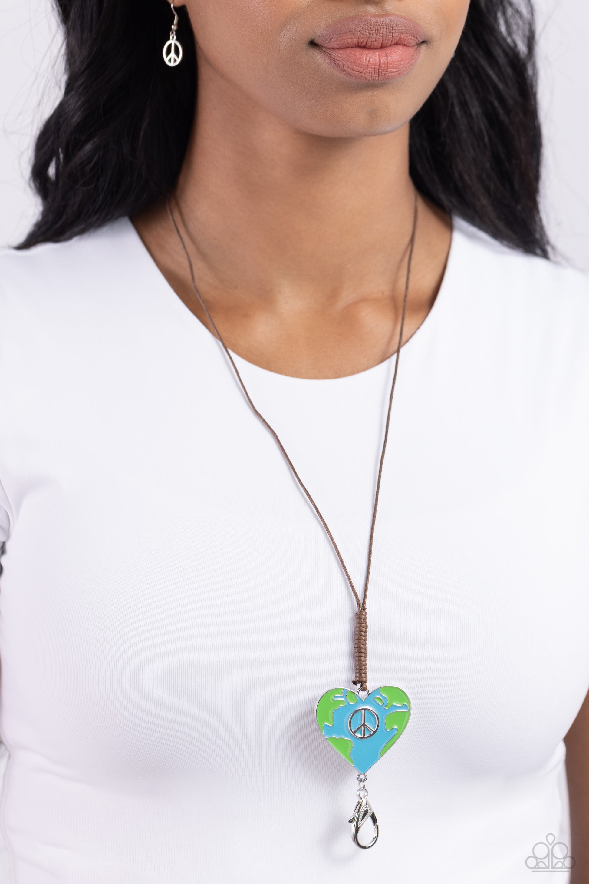 Paparazzi Accessories Earthy Evolution - Blue Featuring a silver peace sign center, a heart frame painted in an earth motif in Classic Green and blue hues is knotted in place at the bottom of a lengthened brown cord for a seasonal flair. A lobster clasp h