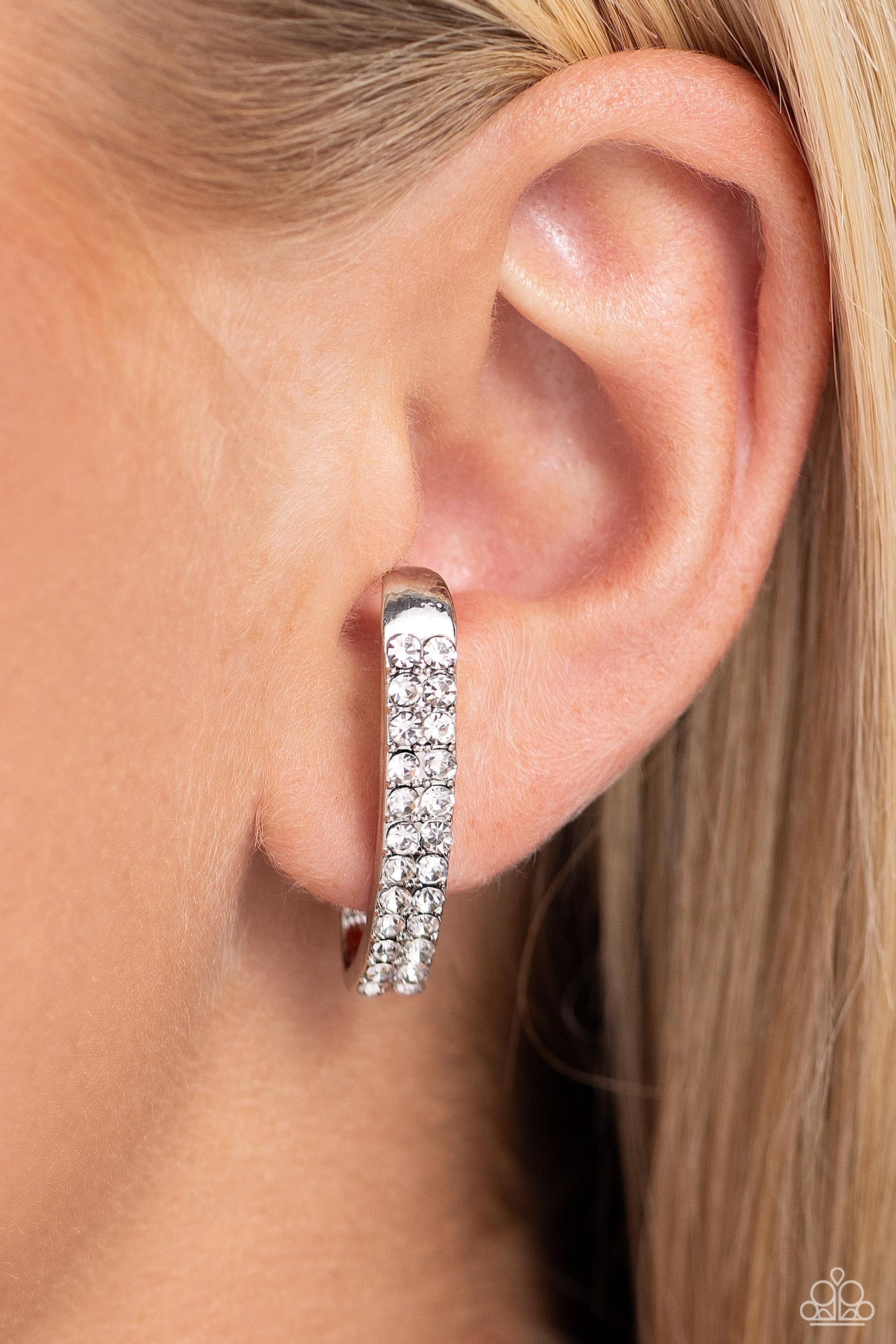 Paparazzi Accessories Sliding Series - White Two rows of glassy white rhinestones are set along the center of a curved silver bar for a refined display of dazzle. Features a sleek surface for sliding ability to desired position on the ear. Due to its stru