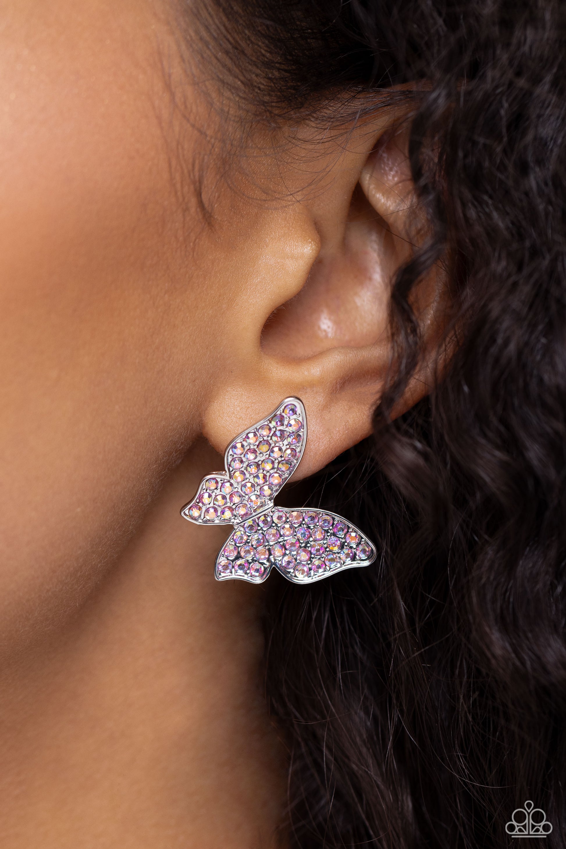 Paparazzi Accessories High Life - Pink Featuring a tilted motif, a silver butterfly encrusted with an explosion of pink iridescent rhinestones sparkles at the ear for an enchanting fashion. Earring attaches to a standard post fitting. Due to its prismatic