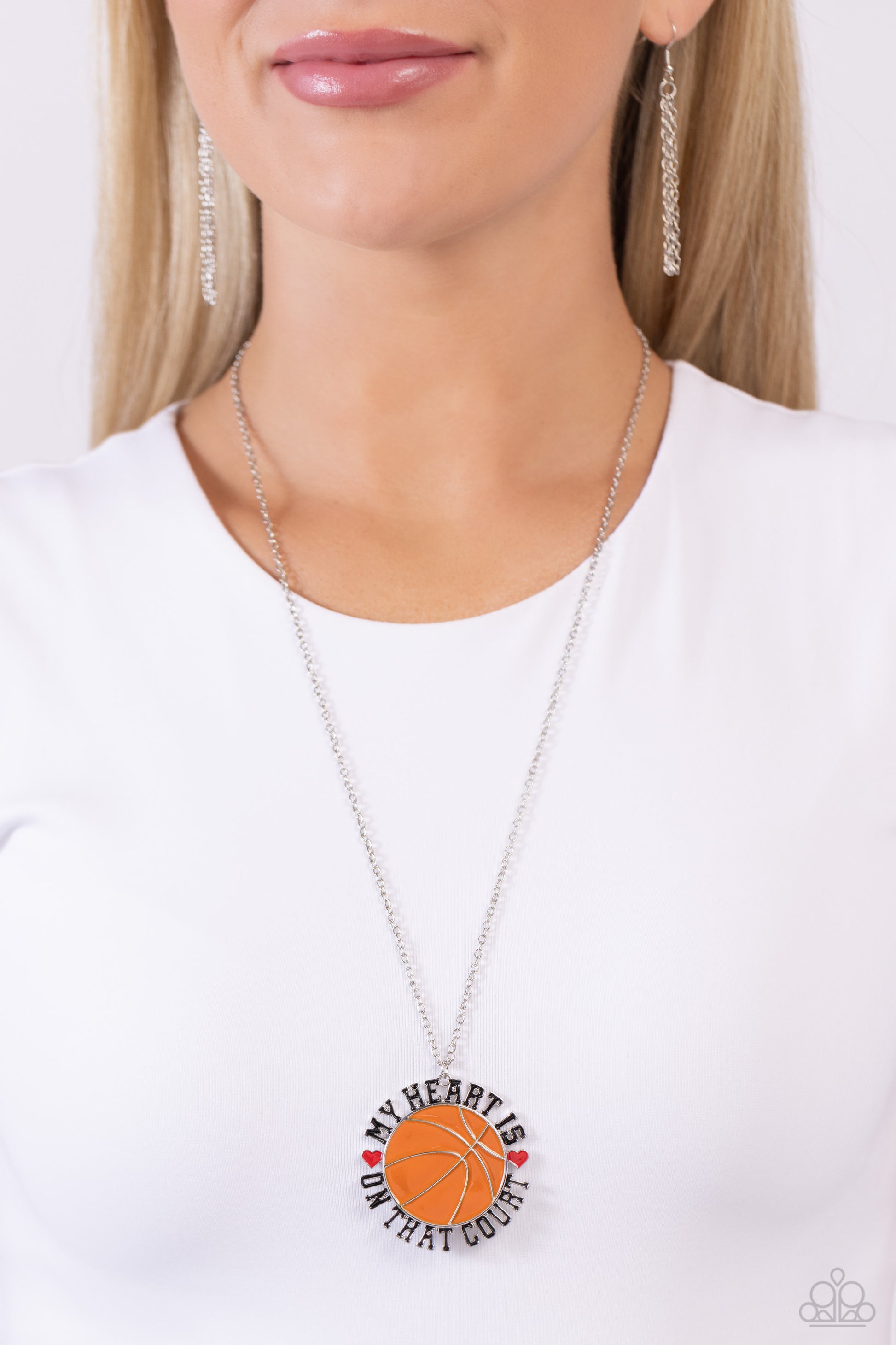 Paparazzi Accessories Courting Courtside - Orange Dangling from an extended dainty silver chain, an oversized orange-painted basketball pendant features the phrase "My Heart is on that Court" in all caps and black lettering as it wraps around the ball. Re
