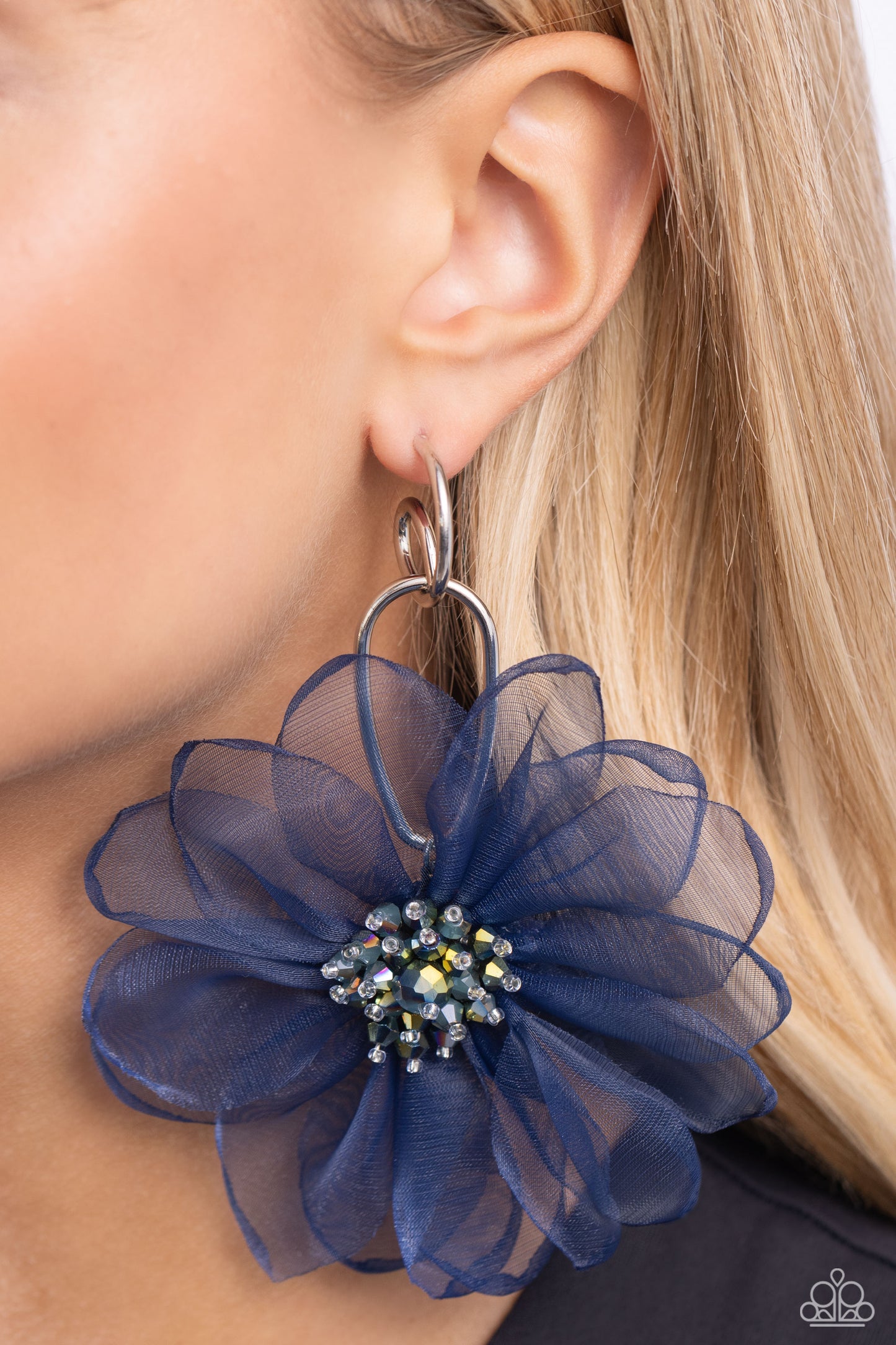 Paparazzi Accessories Cosmopolitan Chiffon - Blue A duo of asymmetrical silver hoops link as they tumble from the ear, coalescing into an abstract lure. Attached to the bottom of the elongated display, oversized navy chiffon petals bloom around oil spill-