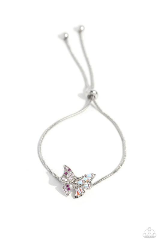 Paparazzi Accessories Adjustable Allure - Pink Dotted with various pink rhinestones and emerald-cut iridescent gems, a silver butterfly flutters along a strand of shiny silver snake chain around the wrist for a wildly whimsical look. Features an adjustabl