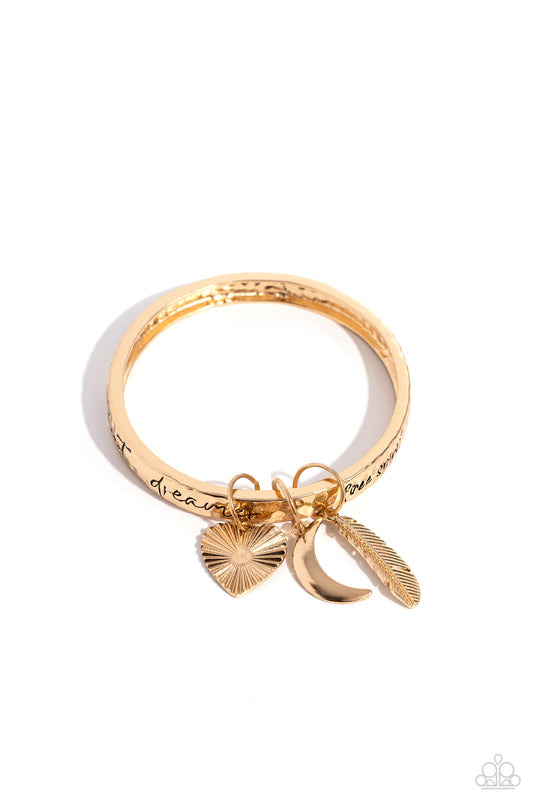 Paparazzi Accessories Free-Spirited Fantasy - Gold A hammered gold bangle featuring a textured feather, sleek crescent moon, and textured heart charms wraps around the wrist for an artisan-inspired fashion. Painted in a black hue, the phrases “free spirit
