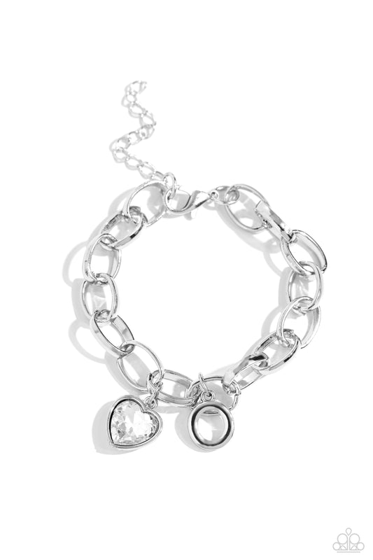 Paparazzi Accessories Guess Now Its INITIAL - White - O A simple collection of silver charms — including a white rhinestone heart pressed in a silver frame and a sleek letter "O" — dance from a chunky silver chain around the wrist, creating a sentimental