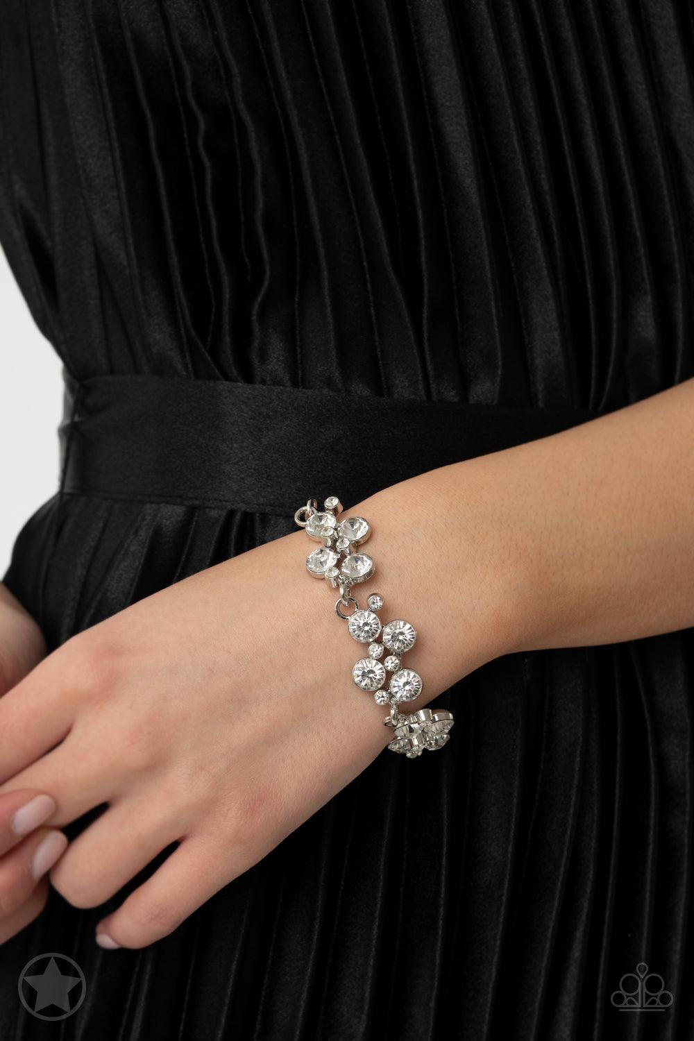Paparazzi Accessories Old Hollywood Clusters of brilliant white rhinestones drape elegantly along the wrist. The scattered pattern and varying sizes of the rhinestones add breathtaking detail to the piece. Features an adjustable clasp closure. Sold as one
